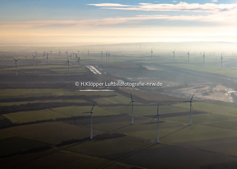 Luftbild Rotorköpfe und Windrad- Rohrtürme von Windenergieanlagen ( WEA ) ragen empor auf einem Feld in Jüchen im Bundesland Nordrhein-Westfalen, Deutschland